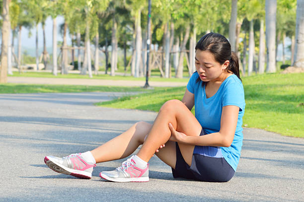 woman in pain while running in park - runner holding legs bildbanksfoton och bilder