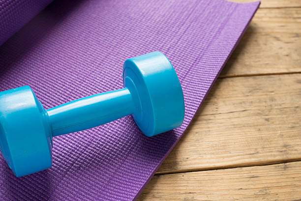 istock dumbbell and yoga mat on wood table 517374800