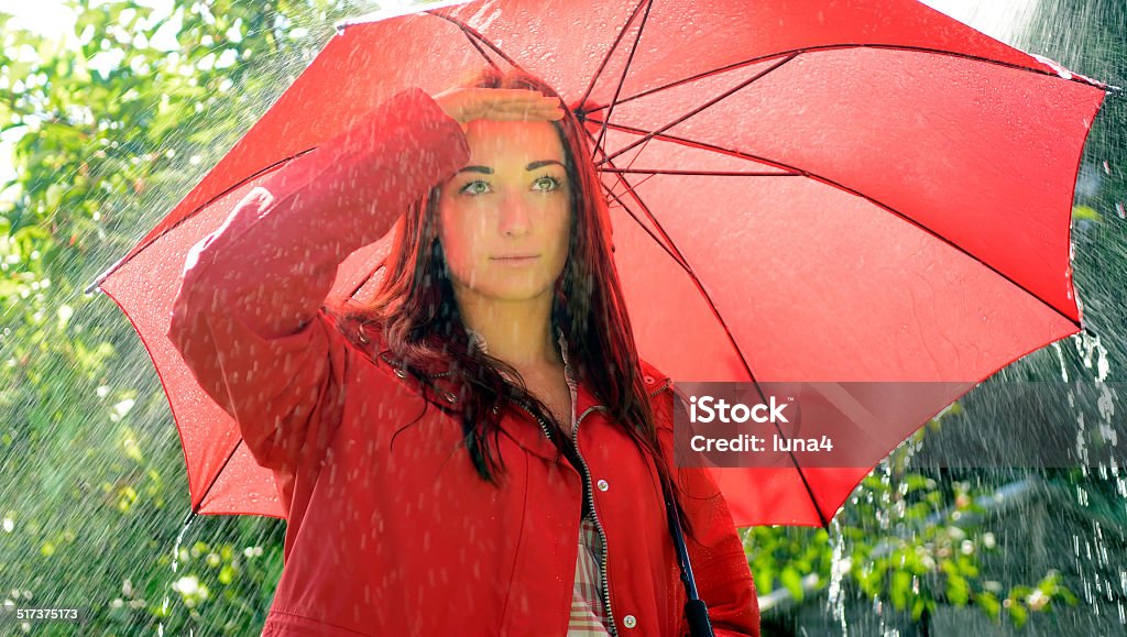 woman looking for rain young woman with red umbrella looking for rain Adult Stock Photo