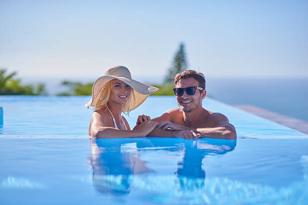 istock Attractive young couple relaxing in awesome pool 517375276