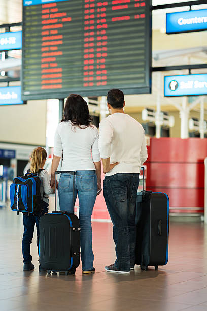 istock family checking flight information at airport 517375565