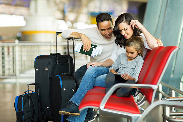 istock young girl with parents using tablet computer at airport 517376275