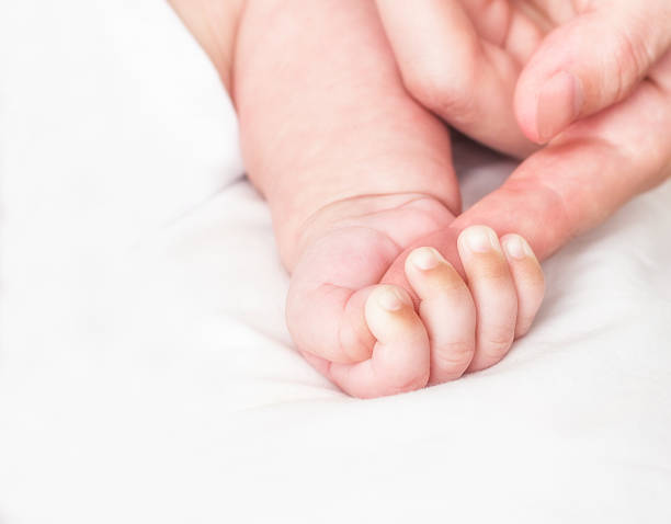 istock Baby and mother's finger 517376821