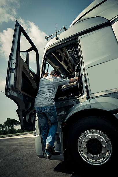 Climbing Into The Truck Driver climbing into the truck disembarking stock pictures, royalty-free photos & images