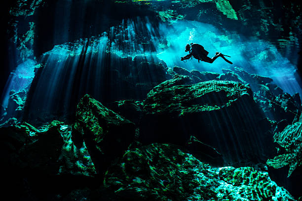 Rocky underwater places Scuba diver exploring the underwater caverns. puerto aventuras stock pictures, royalty-free photos & images