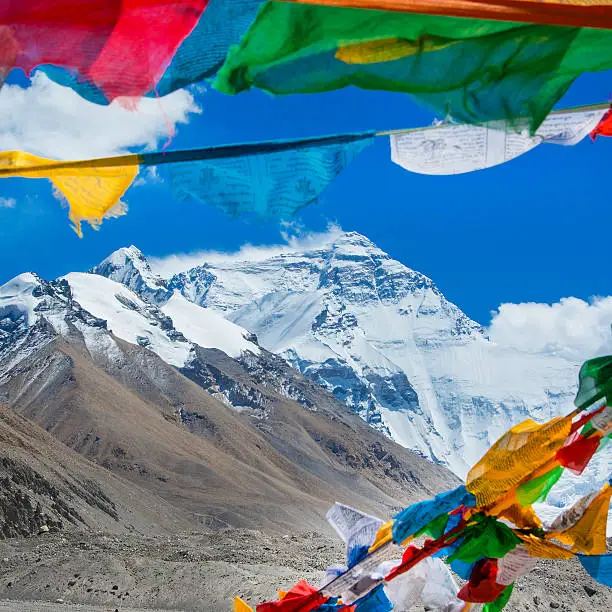 The mighty northface from Mt. Everest, with 8850 m altitude the highest mountain of the world. In the foreground colorful buddhist prayer flags.