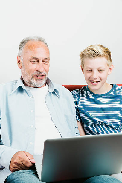 istock Grandson explaining grandfather how to use laptop 517380603