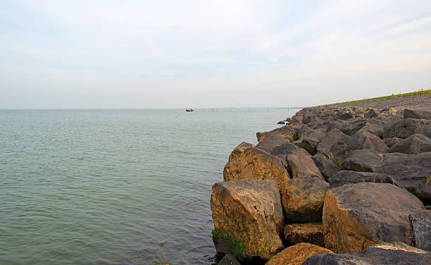 istock Rowboat near a fish trap along a dike 517381019