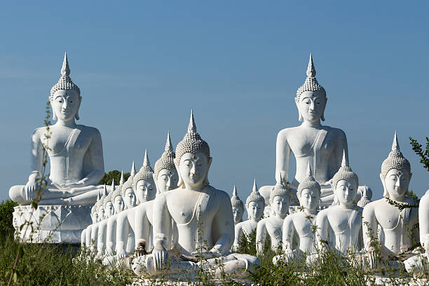 istock raw of white buddha status on blue sky background 517381483