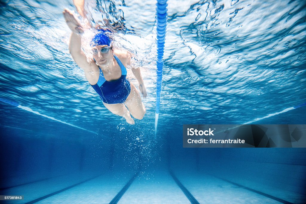 Woman Swimming Freestyle Under water shoot of a woman swimming freestyle in olympic pool Swimming Stock Photo