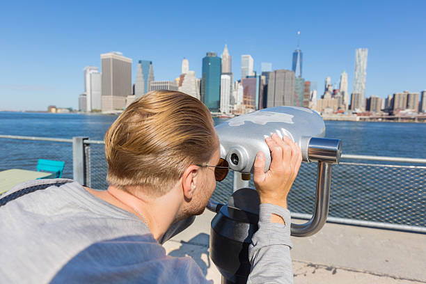 istock Young Man Looking through Binoculars in New York 517382299