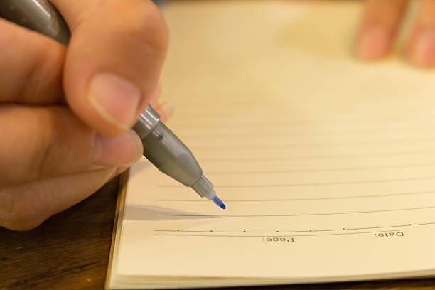 istock female hands with pen writing on book 517383640