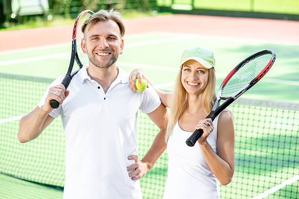 pareja joven jugando al tenis - tennis couple women men fotografías e imágenes de stock