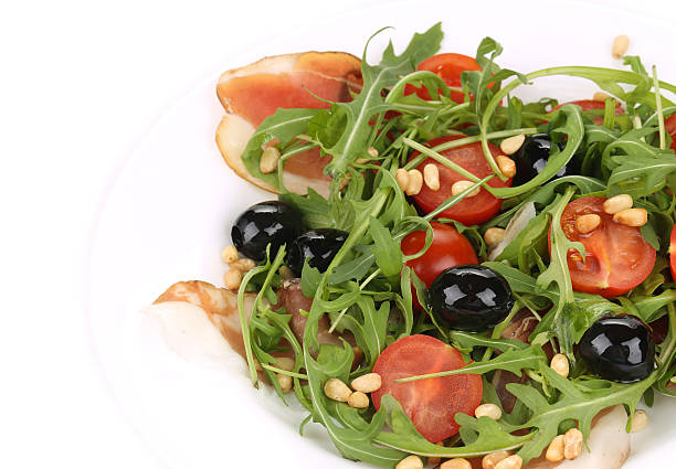 Salad with arugula and prosciutto. Isolated on a white background.