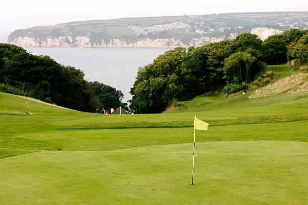 The 1st green looking down the fairway towards the sea on a beautiful coastal links golf course in Devon. Axe Cliff Golf Club, Axmouth, Devon