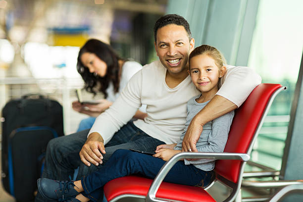 istock father and daughter sitting on airport bench 517399663