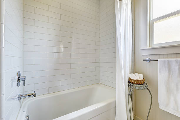 istock Simple bathroom with tile wall trim and bath tub 517400305