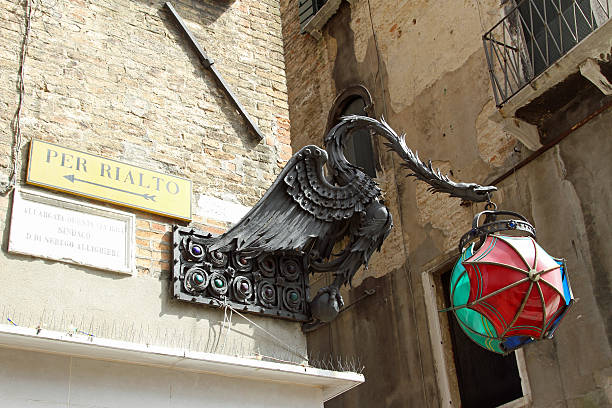 istock signs to Rialto Bridge with the bronze dragon statue 517402773