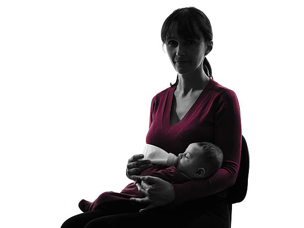 istock woman feeding bottle baby  silhouette 517403139