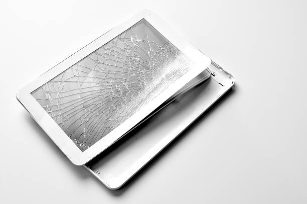 cracked tablet on white desk stock photo