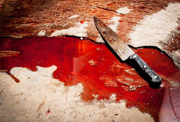 Conceptual image of a sharp knife with blood on floor stock photo
