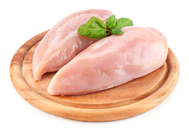 istock Raw chicken fillets on wooden board isolated on white 517411110