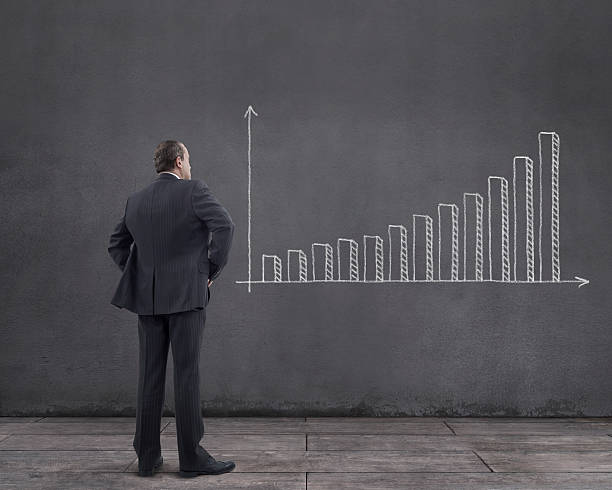 istock Businessman with Increasing Bar Chart Sketched on the Wall 517412376