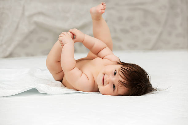 Baby girl lying on blanket indoors stock photo