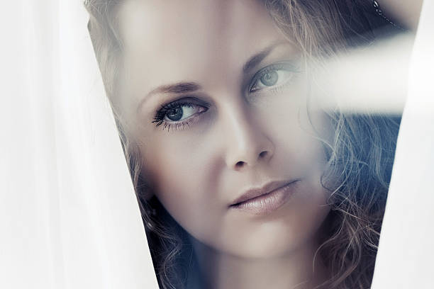 istock Sad beautiful woman looking out window 517413372