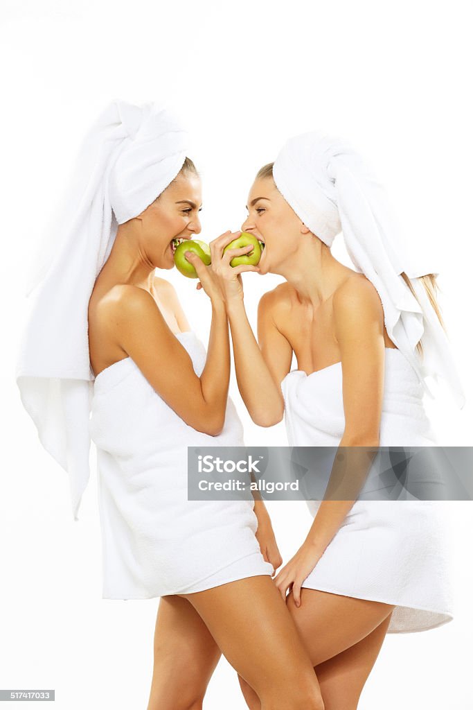 Two happy teen girl after shower playing with apple Adult Stock Photo