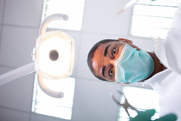 istock scary and funny dentist working with a patient 517418176