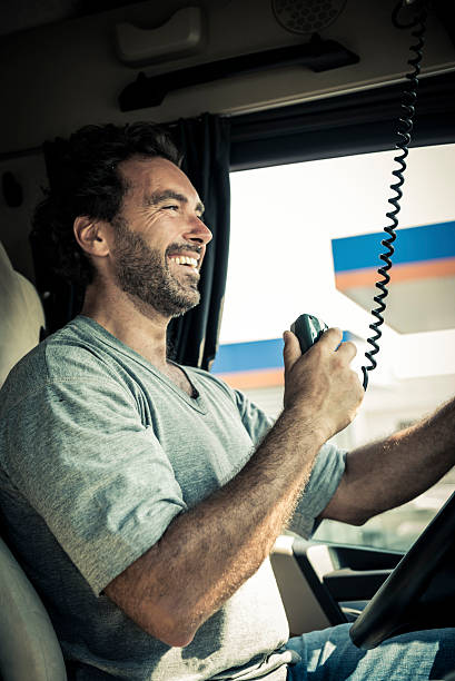 Truck Driver Using His CB Radio Portrait of a truck driver using CB radio semi truck audio stock pictures, royalty-free photos & images