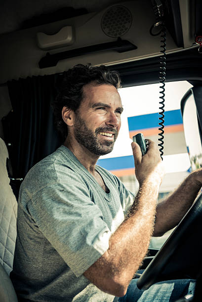 Truck Driver Using His CB Radio Portrait of a truck driver using CB radio semi truck audio stock pictures, royalty-free photos & images