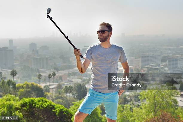 Young Man Making A Photo With Handheld Selfie Stick Stock Photo - Download Image Now