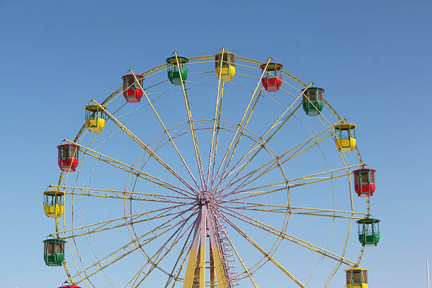istock Ferris wheel with color cabins against the blue sky 517419388