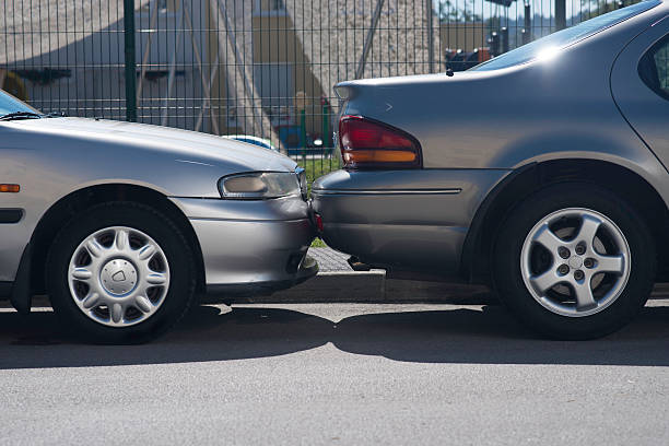 Hitting A Parked Car Hitting into a parked car while parking a vehicle in a parallel line parking space.  bumper photos stock pictures, royalty-free photos & images