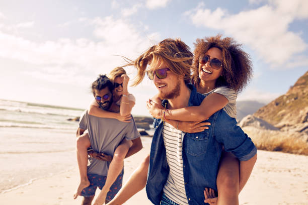 istock Young couple playing piggyback on beach 517420882