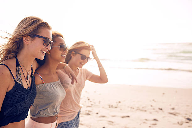 istock Happy young women walking on a beach 517420924