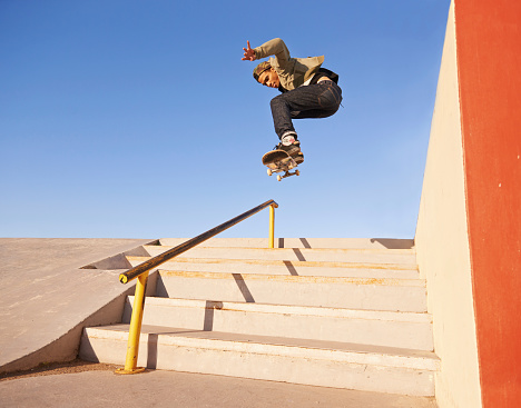 Shot of a skateboarder performing a trick on a rail