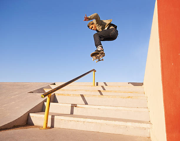 On his grind Shot of a skateboarder performing a trick on a rail skateboarding stock pictures, royalty-free photos & images