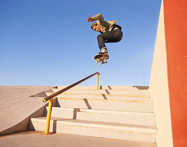 On his grind Shot of a skateboarder performing a trick on a rail skating stock pictures, royalty-free photos & images