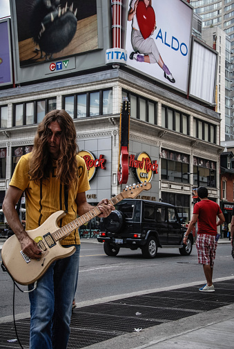 Toronto, Canada - July 5, 2010: Man playing the electric guitar on the street across from the Hard Rock cafe in downtown Toronto, Canada.