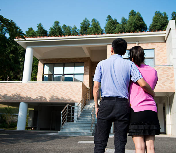 istock couple in front of new home 517442067