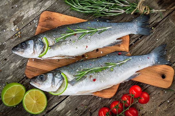 istock Two raw seabass with lime, cherry tomatoes and rosemary 517442391