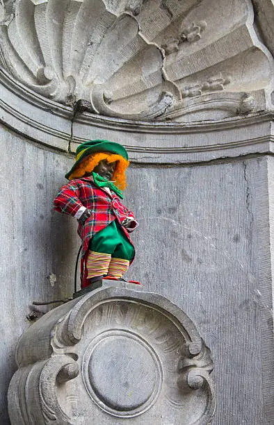 Manneken Pis dressed as a clown red. This is an old Brussels tradition to dress this statue in various funny closes.