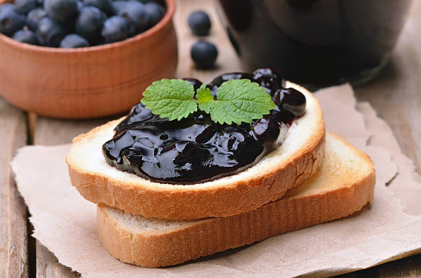 pain grillé avec confiture de myrtille sur table en bois - gelatin dessert blueberry blue dessert photos et images de collection