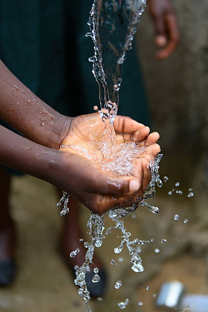 istock Hands of poor child - scoop drinking water, Africa 517445587