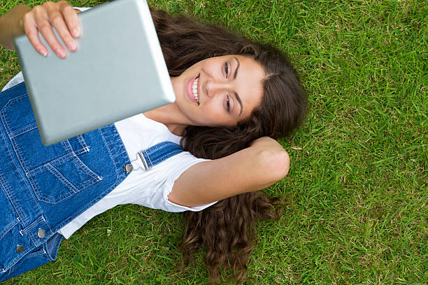 istock Young Woman Lying on Grass 517447669