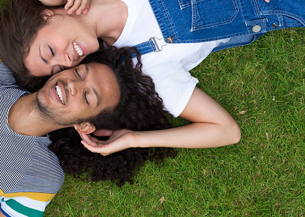 istock Young Couple Lying on Grass Together 517447771