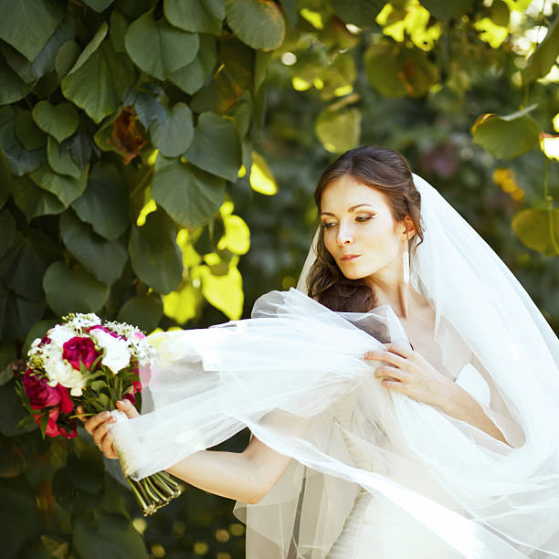 istock Young caucasian bride playing with her veil 517448585